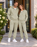 Couple portant les ensembles adultes URIALEX vert sauge avec des baskets blanches.