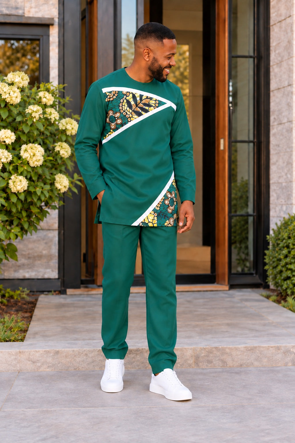 Homme portant l’ensemble URIALEX vert émeraude, tunique à motifs dorés et pantalon de coupe confortable avec baskets blanches.